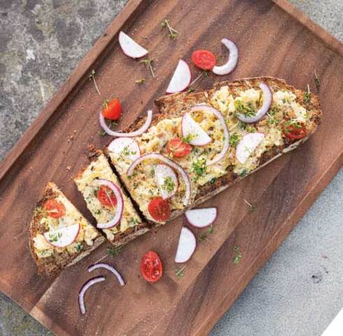 Rösti potato cheese on farmhouse bread with radishes, cress, cherry tomatoes and red onions Image