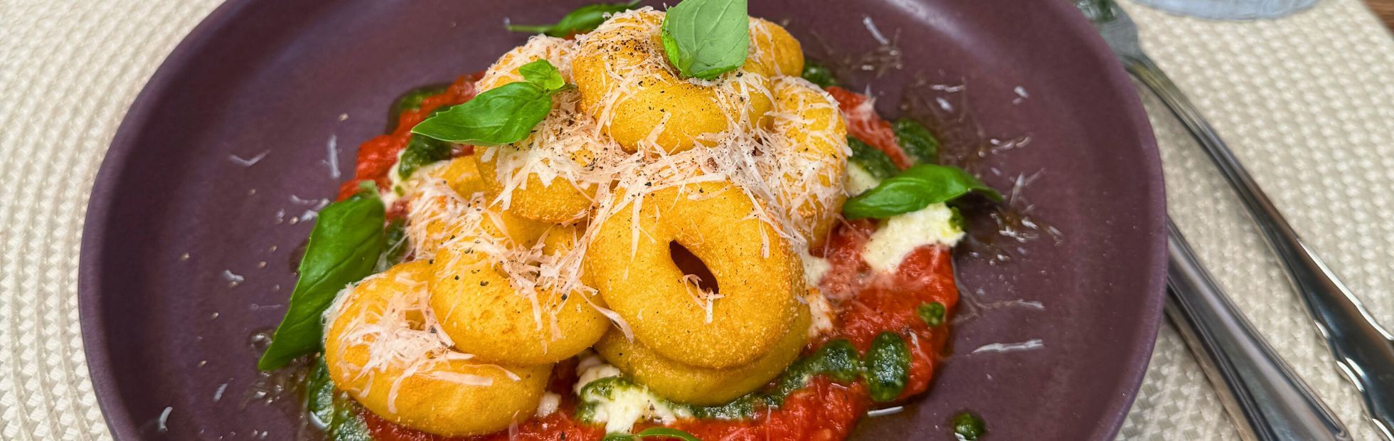Ciambelline di patate 11er su salsa di pomodoro e mozzarella con parmigiano e basilico