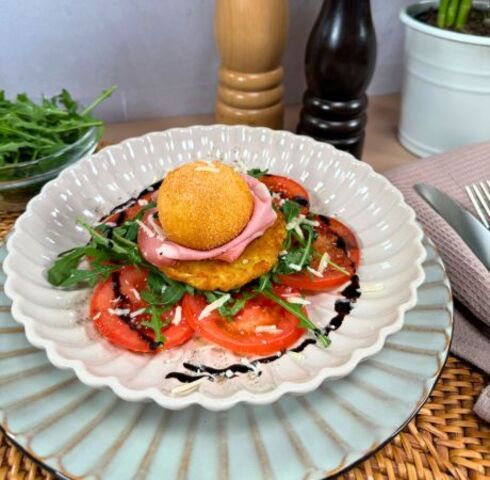 Rösti croccanti con burrata impanata su pomodori marinati, mortadella e rucola Image