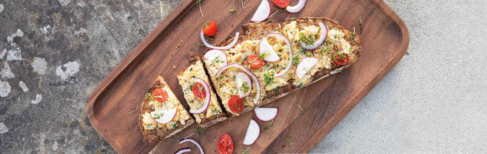 Rösti potato cheese on farmhouse bread with radishes, cress, cherry tomatoes and red onions