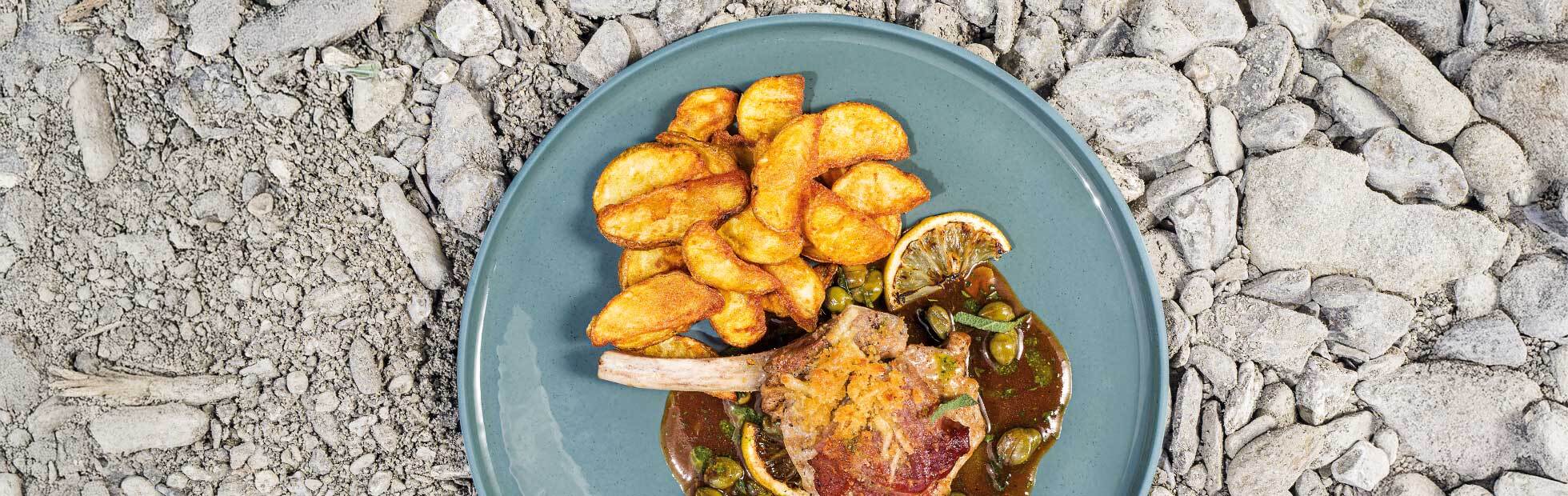 Potato wedges with veal cutlet au gratin and lemon caper sauce