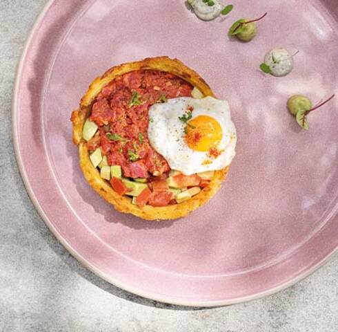 Beef tatar in a crispy Rösti ring with quail egg Image