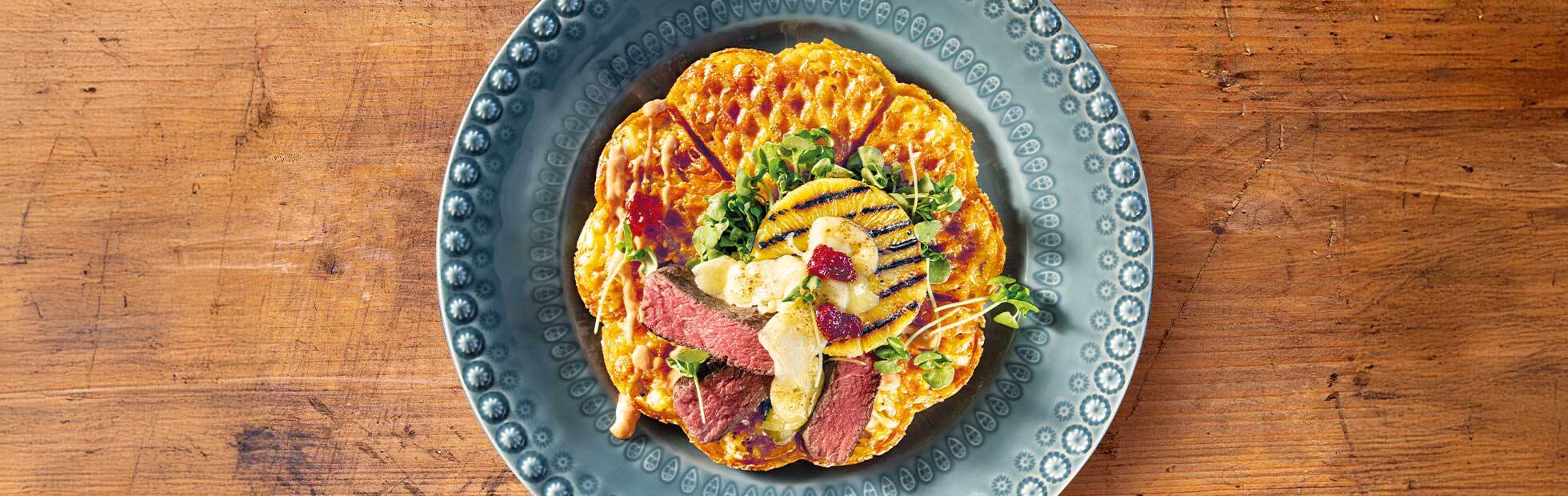 Rösti-Waffel mit Rindsfilet-Scheiben, Ananas und Raclettekäse